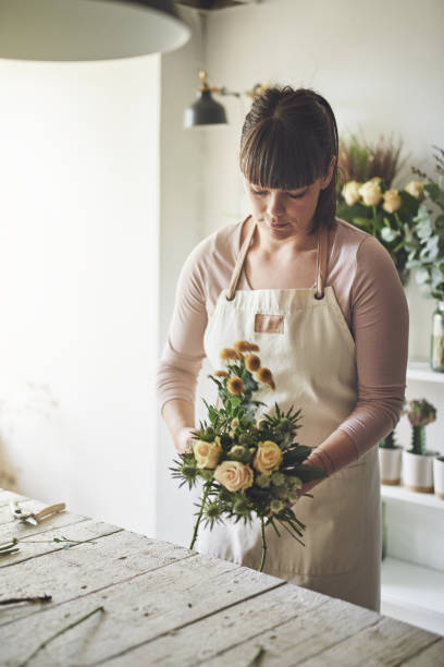 istock Young female florist making a flower bouquet in her workshop 946171366