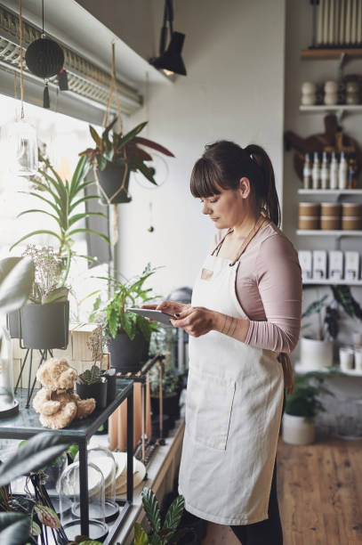 istock Florist using a tablet while standing in her flower shop 946173942
