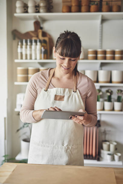 istock Female florist working in her flower shop using a tablet 946176170