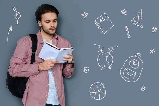 Serious student reading a book before going to the university
