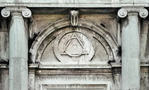 Eye of Providence, inside triangle interlaced with circle above doorway of building in Venice, Italy - It represents the eye of God watching over humanity, or divine providence