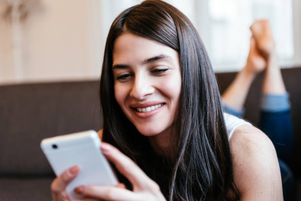 istock Attractive young woman on sofa, using mobile phone. 946182258