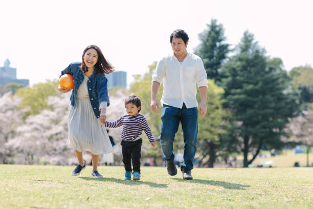 la famiglia giapponese si gode il suo tempo in primavera - park child asia lifestyles foto e immagini stock