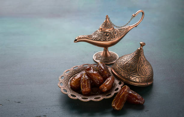 Bronze plate with dates  and aladdin lamp on dark green wooden background. Ramadan background. Ramadan kareem. Bronze plate with dates  and aladdin lamp on dark green wooden background. Ramadan background. Ramadan kareem. iftar photos stock pictures, royalty-free photos & images