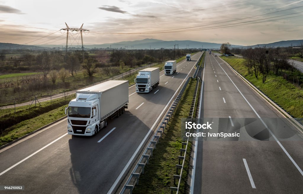 Caravan or convoy of trucks on highway Caravan or convoy of trucks in line on a country highway Truck Stock Photo