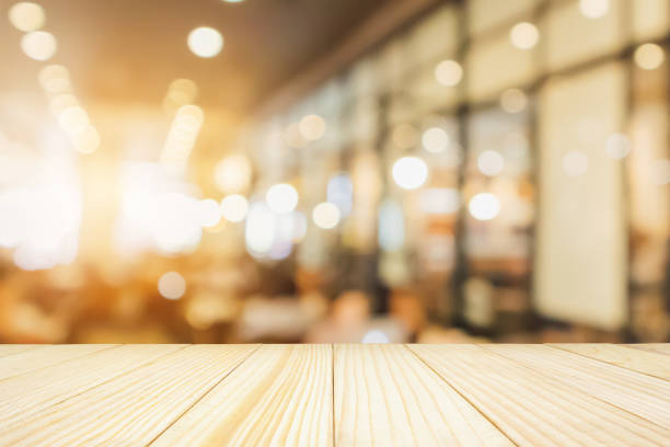 istock Wood table with Restaurant cafe or coffee shop interior with people abstract defocused blur background 946210620
