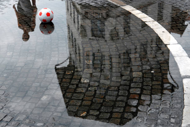 istock Ball in the puddle with reflection of the building 946219422