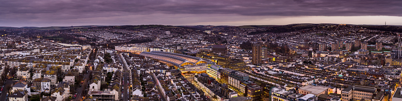 Aerial shot of the city of Brighton, on the southeast coast of England, taken around sunset. The train station is in the centre of the shot.