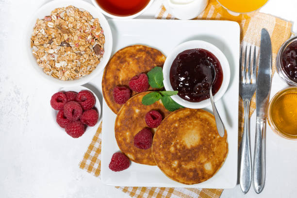 istock delicious pancakes with raspberries and jam for breakfast, top view 946222930