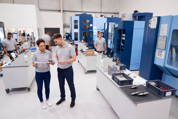 istock Engineers Meeting On Factory Floor Of Busy Engineering Workshop 946236276