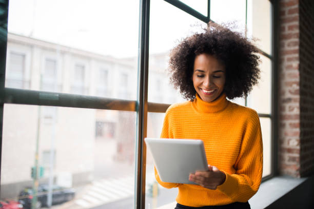 Smiling woman using digital tablet. Smiling African American woman using digital tablet at the work. one business woman stock pictures, royalty-free photos & images