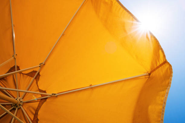 istock Yellow umbrella against the sun and blue sky 946243802