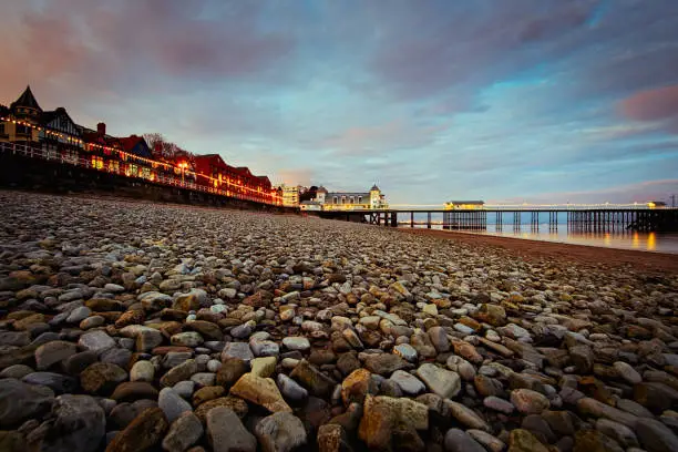 Penarth Pier at Sundown with the pebble beach in the foreground