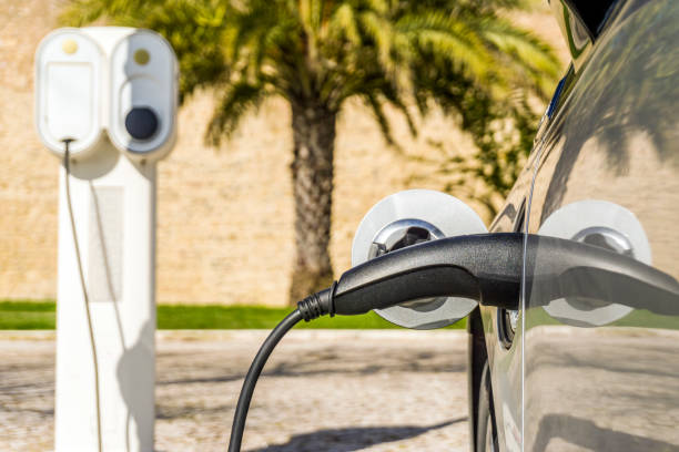 istock Electric car plugged by cable to charging station 946247266