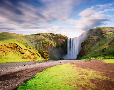 Skogafoss waterfall and Skoga river. Famous landmark of Iceland. Summer landscape on a sunny day. Amazing in nature