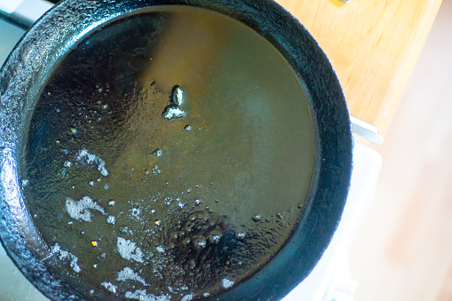 Used vegetable oil in an empty frying pan