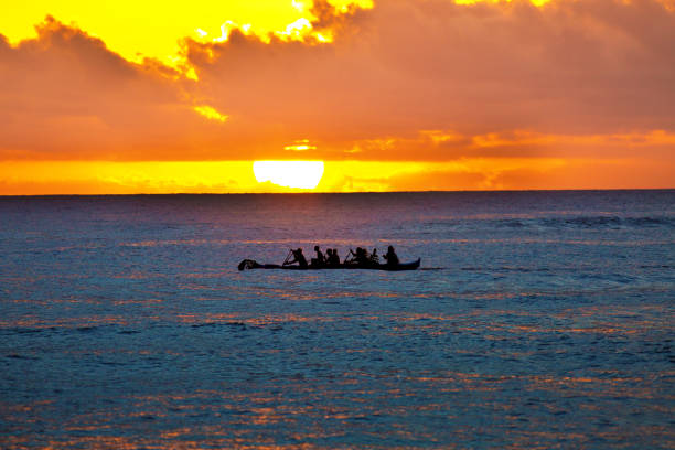 canoa outrigger en puesta de sol, playa de poipu, kauai, hawaii - canoa con balancín fotografías e imágenes de stock