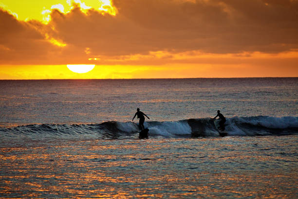 istock Two Surfers at Sunset, Poipu Beach, Kauai,Hawaii 946267676