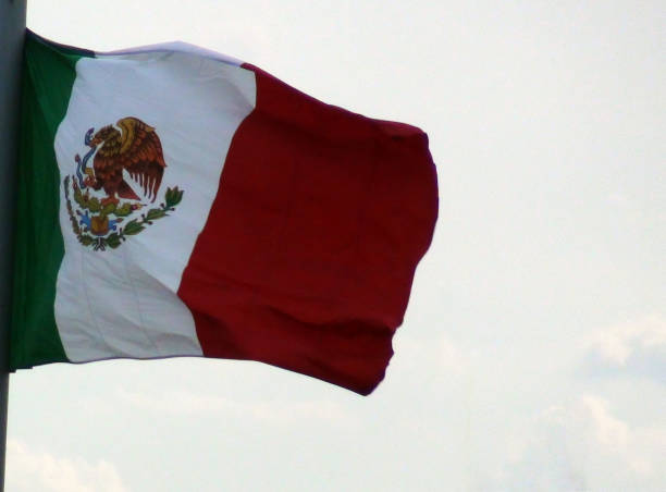 istock Mexican National Flag Against Blue Sky 946268642