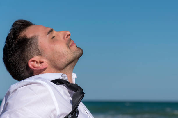 istock Man with tie and white shirt sunbathing on his face 946273610