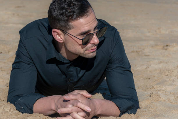 istock Man lying on the sand on the beach 946273684