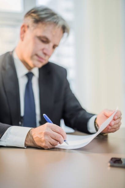 istock Mature businessman signing a document. 946279396