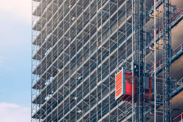 Construction elevator An elevator on the exterior of a tall building under construction. outdoor elevator stock pictures, royalty-free photos & images
