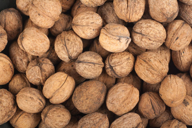 istock Scattered pile of walnuts, background, fresh, walnuts, market. Top view 946286972