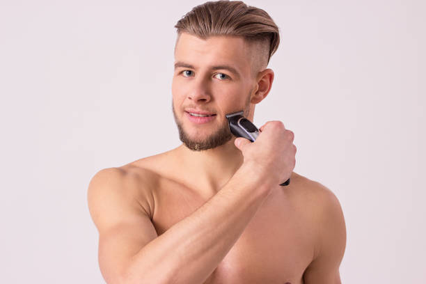istock Attractive man shaving his face with razor 946290822