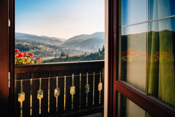 Open door that leads to a balcony overlooking the marvelous view of mountain nature with a taste of  peace and adventures.