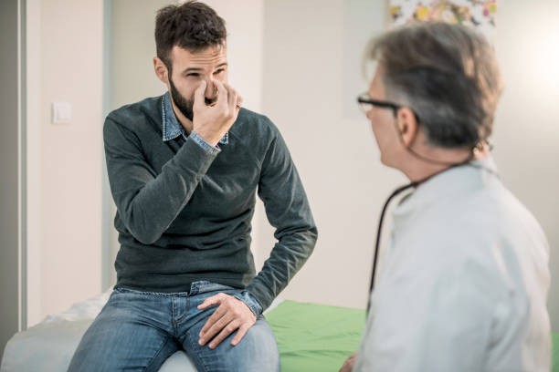 Mid adult patient describing his breathing problem to a doctor. Mid adult patient describing his breathing problem to a doctor. nose stock pictures, royalty-free photos & images