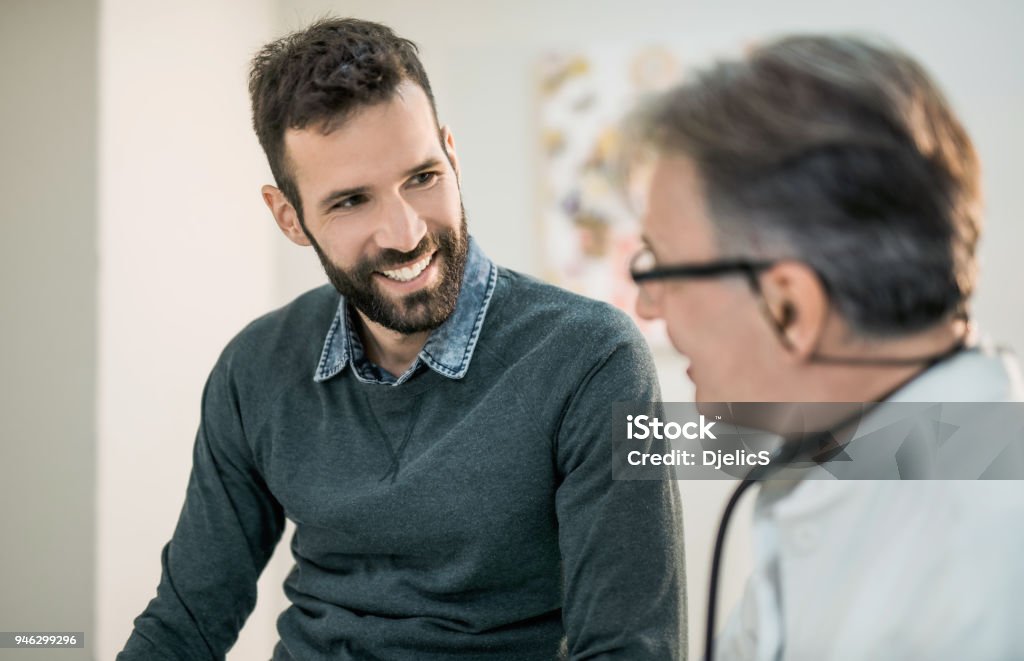 Glücklich Mitte erwachsenen männlichen Patienten im Gespräch mit seinem Arzt. - Lizenzfrei Arzt Stock-Foto