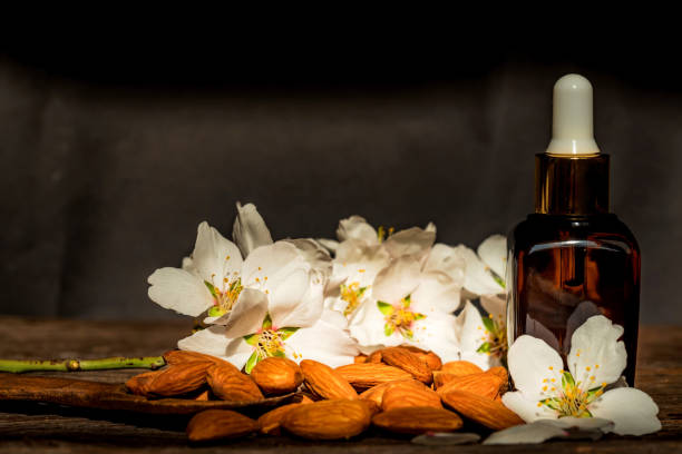 istock Almonds, oil and white flowers on dark background 946306014