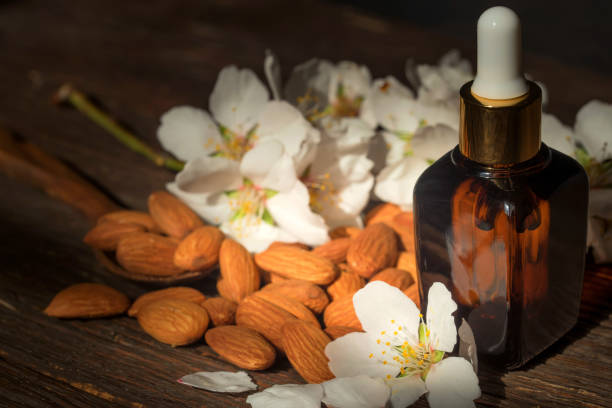 istock Almonds, oil and white flowers on dark background 946306258