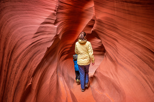Stock photograph of a mother hiking with child in Lower Antelope Canyon in Page Arizona USA.