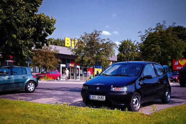 black car Fiat Punto on parking lot for supermarket  in summer south bohemia  during holiday Strakonice, Czech republic - July 14, 2013: black car Fiat Punto on parking lot for supermarket  in summer south bohemia  during holiday punto stock pictures, royalty-free photos & images