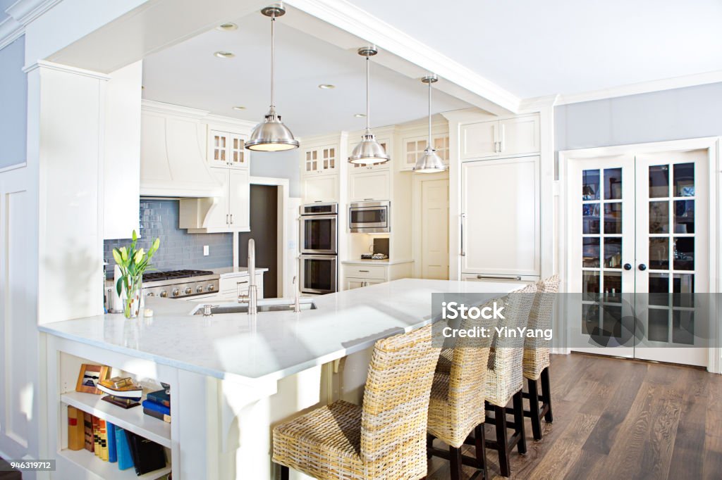 Modern Kitchen design with open concept and bar counter +++NOTE TO INSPECTOR: Photo artwork on the bookshelf is taken by me, see property release.+++

A contemporary kitchen with open concept design and bar counter in a modern home. Kitchen Stock Photo