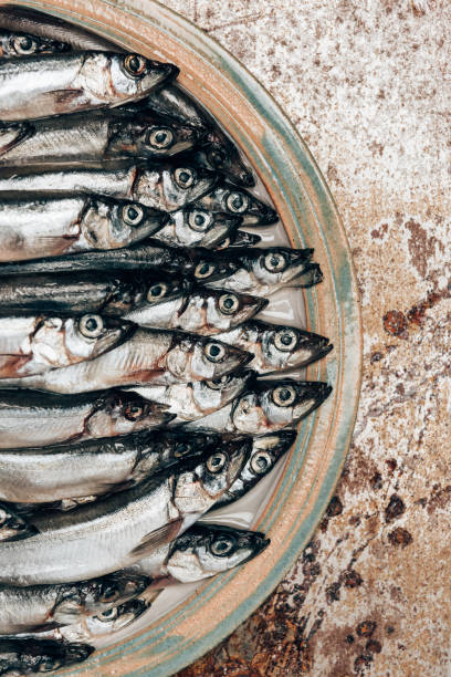 istock Cropped image of pile of fish on plate on rustic surface 946327526
