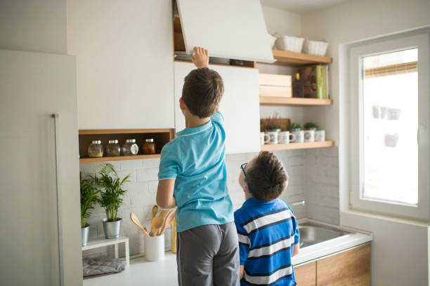istock Brothers stealing cookies in kitchen 946328402