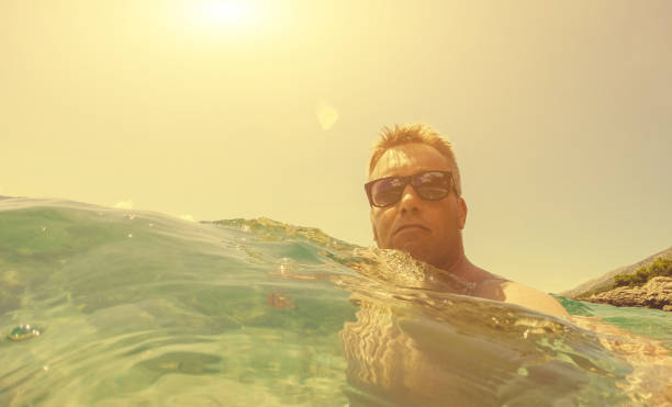 istock Young man relaxing in the sea. Toned Image. 946334792