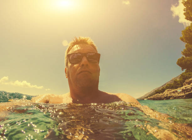 istock Young man relaxing in the sea. Toned Image. 946334796