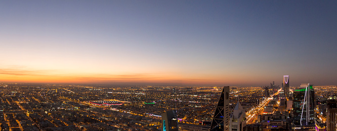Panoramic view of Riyadh city at sunset while lights start turning on