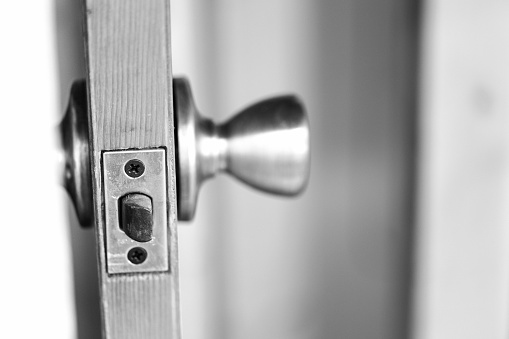 Latch and doorknob on a wood interior door.