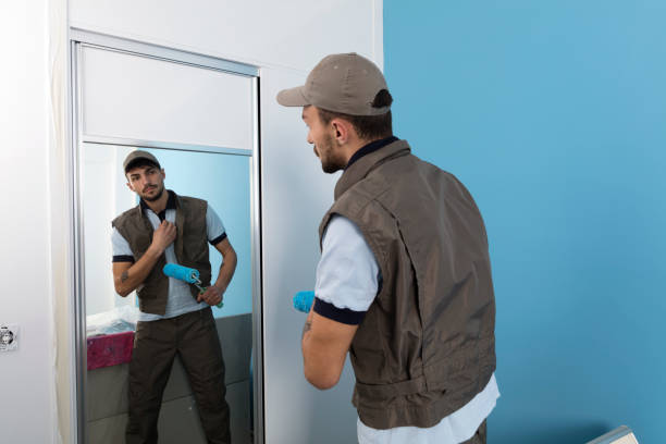 istock Rear view of a handsome man painting a wall blue with a roller 946355428