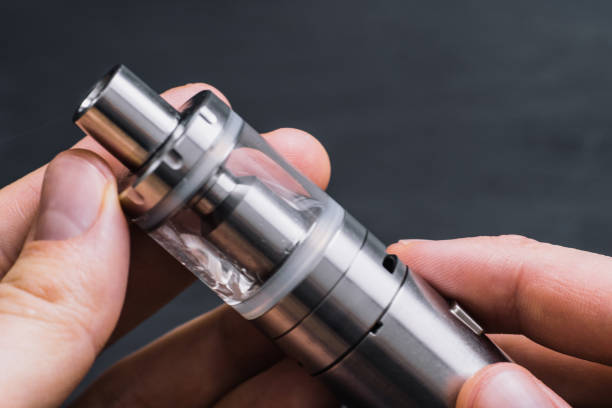 istock Vape. Vaping man holding a mod device. cloud of vape 946363254