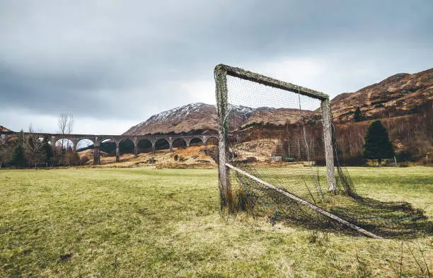Old soccer gate on the green grass playground near the famous Glenfinnan viaduct in Scotland, United Kingdom.