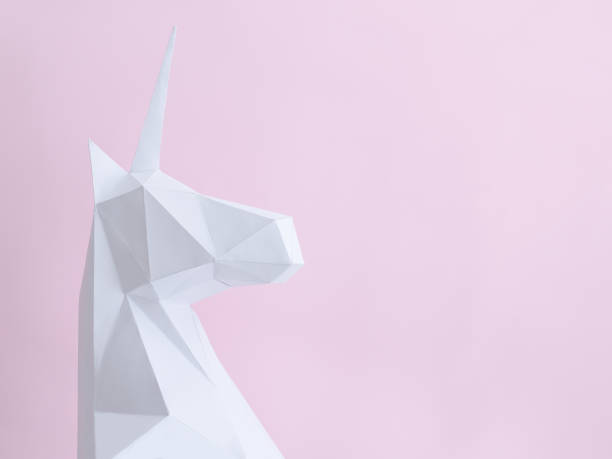 istock White paper unicorn on a pink background. Space for text 946363732