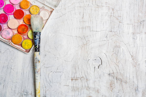 Watercolor Paint Pots Overhead view - art supplies with whitewashed wood background and paintbrush