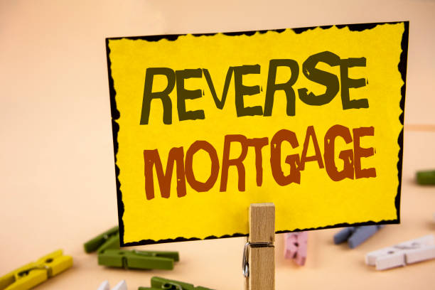istock Handwriting text writing Reverse Mortgage. Concept meaning Elderly homeowner retirement option regular payment benefit written on Yellow Sticky Note Paper on the plain background Wooden Clips 946373896