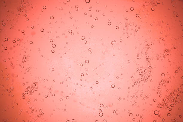 istock Rain droplets on red glass background, Water drops on glass. 946382214